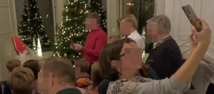 Zwei junge Frauen machen ein Selfie mit dem Nikolaus im Hintergrund.