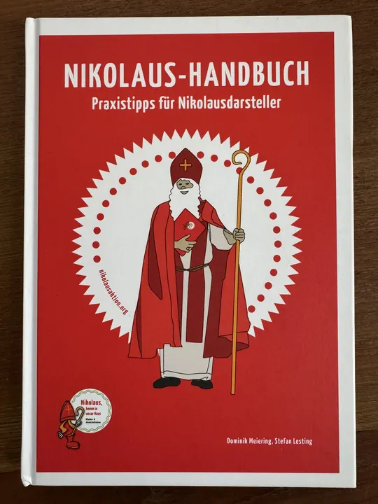 Titelseite des Nikolaus-Handbuch der Bund der Deutschen Katholischen Jugend. Gezeichneter Nikolaus auf einem weißen Kreis mit rotem Hintergrund.